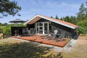 a house with a deck with chairs and a grill at C11216-Hemmet-Ildervej-5 in Hemmet