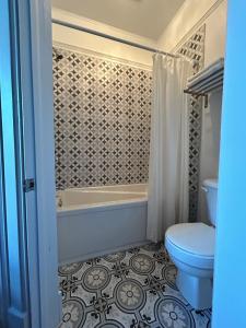 a bathroom with a toilet and a tub and a sink at Auberge La Seigneurie in Matane