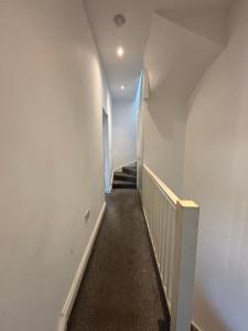 a hallway with white walls and a stair case at Bel Palace in Hackbridge +17 photos