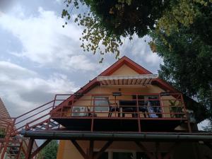 a house with a balcony on top of it at Fűzfa Apartmanház in Tamási