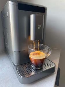 a coffee maker is making a cup of coffee at Apartament Rubinkowo in Toruń +22 photos