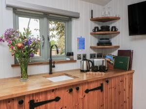 a kitchen counter with a vase of flowers on it at Damsons in Taunton