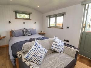a bedroom with a bed and a couch with pillows at Damsons in Taunton
