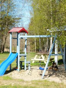 a playground with a blue slide and a bench at Zapach Morza - A Casa Mia in Niechorze