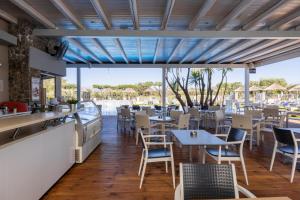 a restaurant with tables and chairs and a counter at Villa Afroditi by Bostonia Village in Almiros Beach