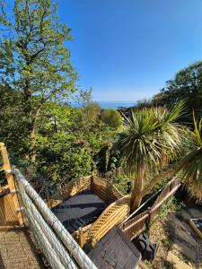 a wooden bridge over a walkway with a palm tree at Seascape Spa Retreat in Niton