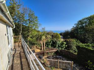 a balcony of a house with a fence and trees at Seascape Spa Retreat in Niton