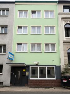 a green building with a door in front of it at Dana Living Apartment Bremen HBF - Zentrum, Altstadt, Messe, ÖVB Arena, Business Apartment mit Self Check-in in Bremen