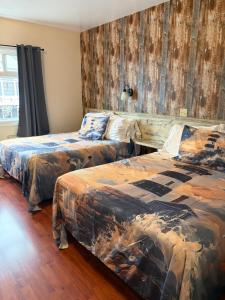 a bedroom with two beds and a wooden wall at Shoreline Suites in Digby