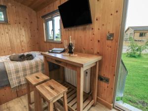 a wooden cabin with a desk and a tv on the wall at Pippins in Taunton