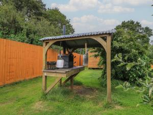 a grill in a yard with a gazebo at Pippins in Taunton