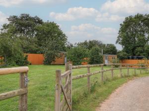 a wooden fence next to a field with houses at Pippins in Taunton +3 photos