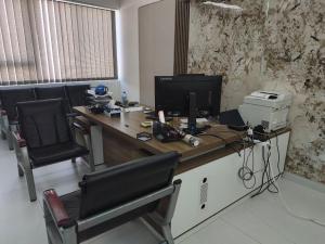 an office with a desk with a computer and chairs at مكتب للايجار in Ma‘ābīlah