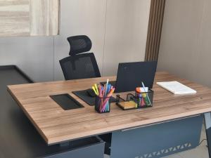a desk with a laptop and a cup of pens at مكتب للايجار in Ma‘ābīlah