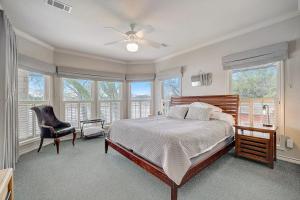 a bedroom with a bed and a chair and windows at Lakeside, Dog-Friendly Living with Kayaks, Boat Ramp, Pool Table & Ping-Pong in Kingsland