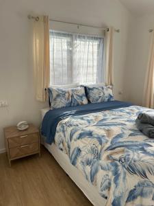 a bedroom with a blue and white bed with a window at Hildas Villa in Arorangi +13 photos