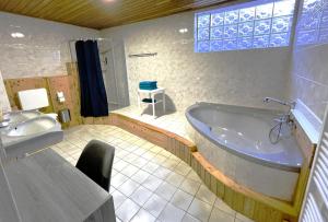 a large bathroom with a tub and a sink at Blue Lagoon Holiday Apartments & Double Room with Balcony in Nehren +55 photos