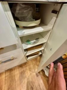 a person reaching into a drawer of a kitchen cabinet at Blackpool cosy cottage in Blackpool