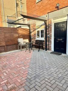 a patio with a table and a bench and a building at Blackpool cosy cottage in Blackpool