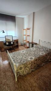 a bedroom with a bed and a desk and a chair at Casa Mediterrània in Xeraco