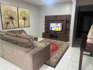 a living room with a couch and a tv at Apartamentos nadai apto 202 in Foz do Iguaçu