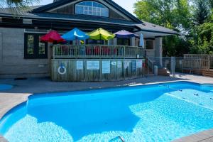 a house with a swimming pool with umbrellas at Blue Cave Escape - Pool Hot Tub & Shuttle in Blue Mountains