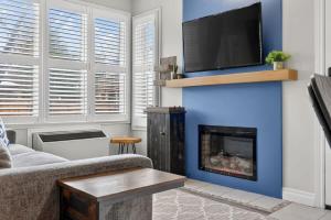 a living room with a fireplace with a flat screen tv at Blue Cave Escape - Pool Hot Tub & Shuttle in Blue Mountains