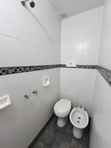 a white bathroom with a toilet and a sink at Hotel Histórico San Telmo in Buenos Aires