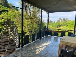 a balcony with a hammock and a table and chairs at Quiet house in Buknari