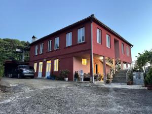 a red house with a car parked in front of it at Quiet house in Buknari