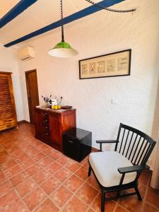 a living room with a chair and a table at Villa Mediterraneo Rooms Piscina jardin parking in Blanes