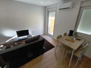 a living room with a dining room table and a desk at Xeliña B in A Estrada