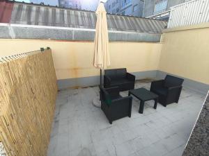 a patio with two chairs and an umbrella at Xeliña B in A Estrada