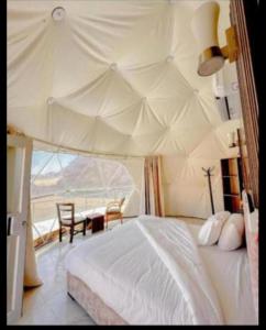 a bedroom with a bed and a table with chairs at Camp in Wadi Rum in Maḩaţţat Dīsah