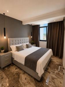 a bedroom with a large bed with a large window at Grand Clochē in Ulcinj