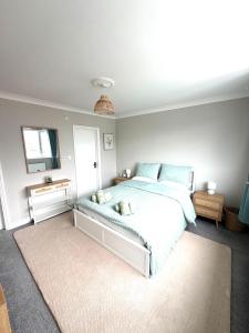 a bedroom with a large white bed with a mirror at Joshua House in Newquay