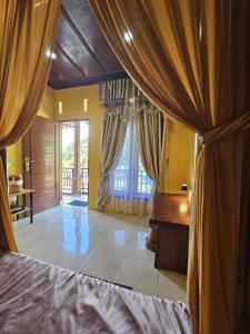 a bedroom with yellow walls and a bed with curtains at Sumatra Inn & Travel in Bukit Lawang