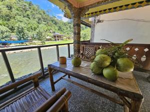 a table with coconuts on it next to a river at Sumatra Inn & Travel in Bukit Lawang +5 photos