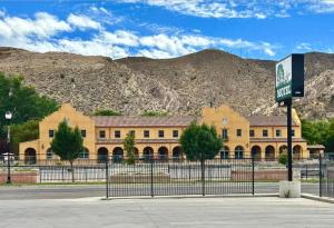 a building with a fence in front of a mountain at Shady Motel in Caliente