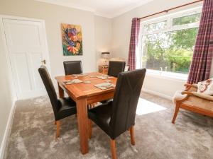 a dining room with a table and chairs and a window at Sundale in Strathaven +20 photos