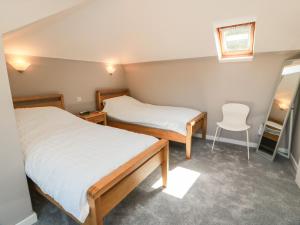 a room with two beds and a chair in it at Sundale in Strathaven