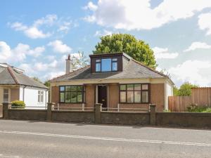 a brick house with glass windows on a street at Sundale in Strathaven