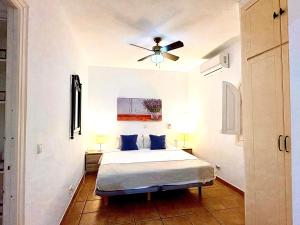 a bedroom with a bed and a ceiling fan at Villa Tranquilla - Sea View Apartments with Pool - Walk to Beach - Family and pet Friendly in Estepona +70 photos