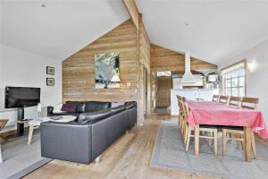 a living room with a black leather couch and a table at C11206-Hemmet-Ildervej-7 in Hemmet