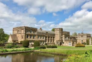 an old castle with a lake in front of it at Yawlings in Holditch