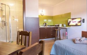 a room with a bed and a table and a kitchen at Pokoje Mirów1A in Mirów