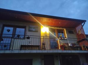 a house with a balcony with a light on it at Pokoje Mirów1A in Mirów