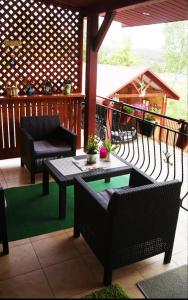 a patio with a table and chairs on a porch at Pokoje Mirów1A in Mirów
