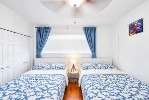 a bedroom with two beds and a window at The Golfstream Dunes Villa in Hallandale Beach