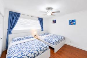 a bedroom with two beds and a ceiling fan at The Golfstream Dunes Villa in Hallandale Beach